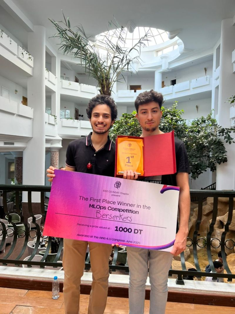 With Ahmed Ben Rejeb and the first-place trophy for the MLOps competition, June 2026.